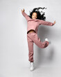 © FAB.1 - Cheerful asian couple in modern pink color with hood, pants and white sneakers jumping flying over white background