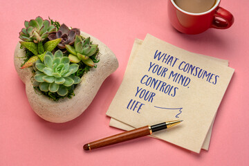 Wall Mural - What consumes your mind, controls your life - inspirational handwriting on a napkin with a cup of coffee, reminder and personal development concept