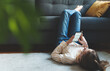© M-Production - Tween girl with smartphone relaxing at home.
