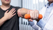 © Ngampol - Young asian physiotherapist helping male patient stretching arm during exercise correct with dumbbell