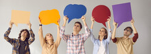 Group Of Young People Standing On Gray Studio Background, Looking Up At Multicolored Empty Cardboard And Paper Mockup Speech Bubbles, Giving Feedback, Sharing Important Message, Expressing Own Opinion