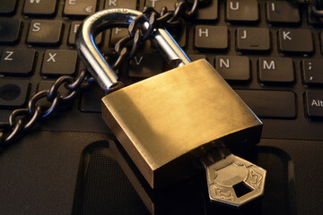 Detail of a metallic security padlock above a computer keyboard,