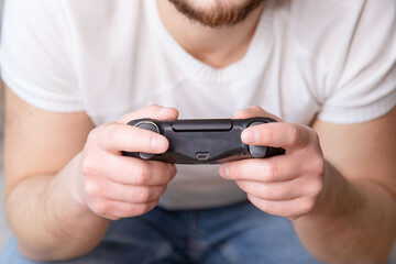 Young man hands holding joystick with serious acting.