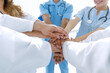 © ASDF - Doctors and nurses in a medical team stacking hands