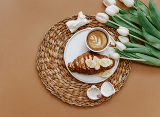 Canvas Print - Mothers Day, 8 march,  Good morning. White Fresh Tulips, Coffee cup and croissant on brown background, top view, flat lay