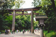 Traditional wooden lamp and great torii gate and tourist and visitors at Meiji Shrine in Yoyogi Park, Tokyo, Japan