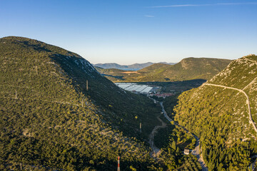 Wall Mural - Aerial drone shot of City Wall of Ston over hill with view of Salt Pan in Croatia sunrise