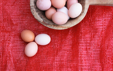 eggs in wooden bowl and red background, top view. Space for text.