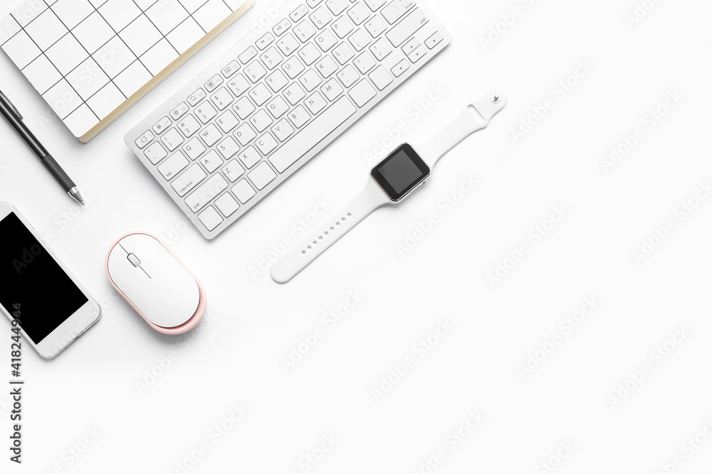 Modern smart watch, computer keyboard, mobile phone and notebook on white background
