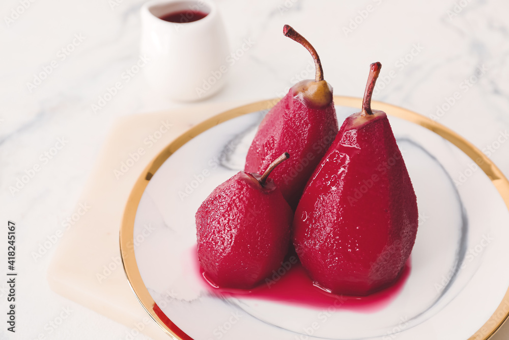 Plate with sweet poached pears in red wine on light background