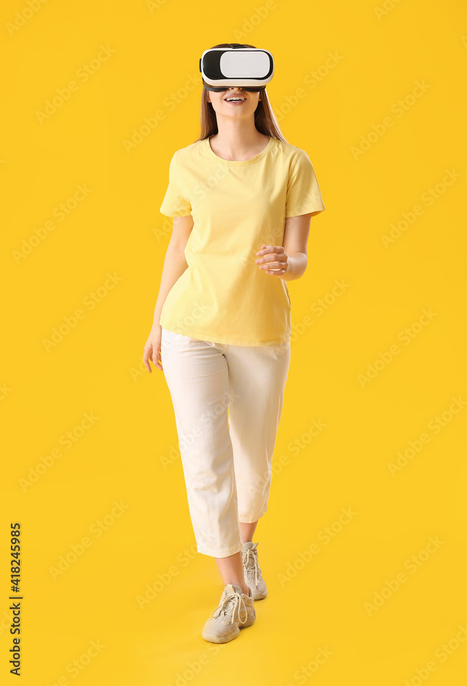 Young woman with virtual reality glasses on color background