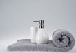 grey terry towel with liquid soap dispenser on a light background