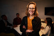 © StratfordProductions - Portrait of a smiling young confident businesswoman in front of her colleagues sitting at desk