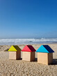 © Valeriia - Colourful blue yellow red miniature wooden kids toy home model on sunny sand beach with blue sky, ocean background. Copy space of family lifestyle and business real estate property investment concept