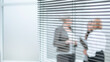 © yurolaitsalbert - through the blinds. group of employees standing in a bright office