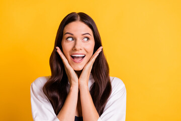 Poster - Portrait of positive charming girl hands palms on cheeks look empty space isolated on yellow color background