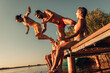 © Zoran Zeremski - Young friends having fun enjoying a summer day swimming and jumping at the lake.