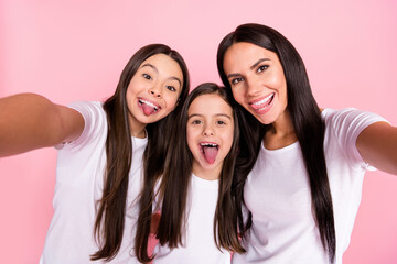 Sticker - Photo portrait of smiling happy family mother and daughters talking selfie showing tongues isolated pastel pink color background