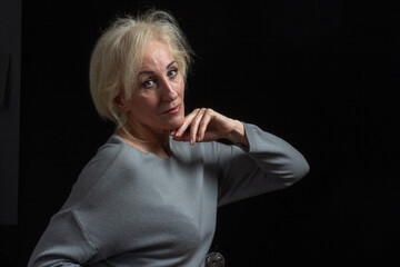 Classic portrait of elderly blonde woman in Studio on black background