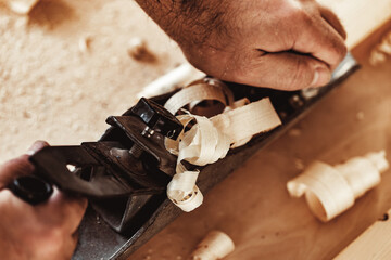 Wall Mural - Carpenter's hands planing a plank of wood with a hand plane