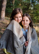 © Julia - Two little girl friends hugging in the forest, wrapped in one plaid, friendship concept, summer time