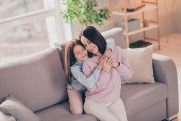 Poster - Photo of optimistic brunette red hairdo mom daughter hug closed eyes on sofa wear sweater at home