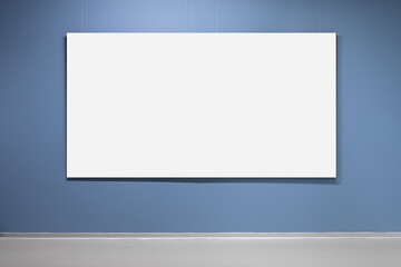 Blank white poster is on blue wall