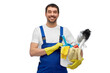profession, service and people concept - happy smiling male worker or cleaner in overall and gloves with cleaning supplies over white background
