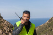 © adradaguajardo - Road maintenance worker during the coronavirus pandemic, on a road with a stop sign and reflective vest