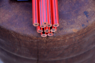 Canvas Print - Closeup shot of red and black wooden pencils on a dark smooth surface