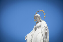 Prayer Virgin Mary Ancient Statue Against Blue Sky. Faith, Religion, Love, Hope Concept.