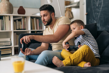 Canvas Print - father and son playing video games in living room