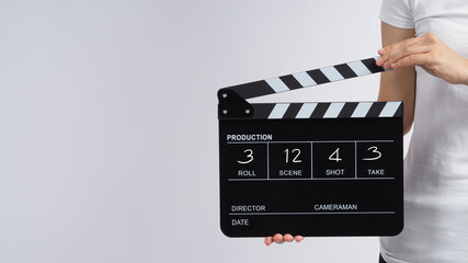 Woman is standing and hands is holding black Clapperboard or movie slate write in number. it use in video production ,film, cinema ,movie industry on white background.