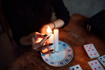 a fortune teller lights ritual candles to predict the future using cards