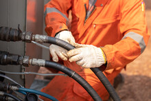 Action of worker hand is connecting and checking to high-pressure hydraulic hose line of  power pack engine. Industrial working action photo, Close-up and selective focus. 