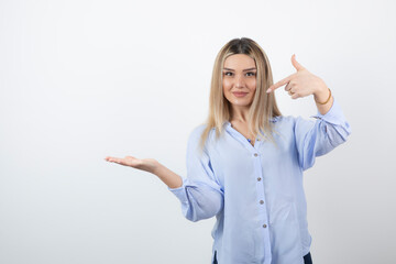 Wall Mural - Young pretty woman standing and posing on white background