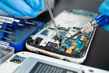 Wall Mural - Technician repairing inside of mobile phone by soldering iron. Integrated Circuit. the concept of data, hardware, technology.