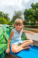 child girl is sitting on the boat. selective focus.