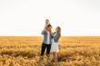 © Shopping King Louie - Happy family, Mother, father and son walk in the wheat field and enjoy
