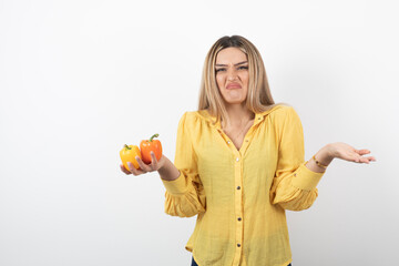 Portrait of blonde woman holding colorful bell peppers