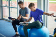 © Connect Images - Runners stretching on exercise balls in indoor running track