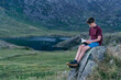 © Image Source - Boy reading book on hilltop, Snowdonia, Llanberis, Gwynedd, UK