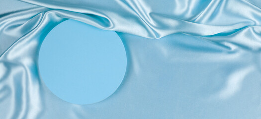 Wall Mural - Geometric round platform podium on light blue silk satin background. Blank minimal cylinder form mock up background for cosmetic product presentation. Top view