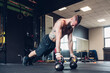 © Connect Images - Young man training in gym, doing push ups from kettle bells