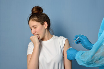 Closeup of doctor giving Covid-19, AIDS or flu antivirus vaccine to patient. Doctor holding syringe making covid 19 vaccination injection dose in shoulder of female patient. Young girl in pain