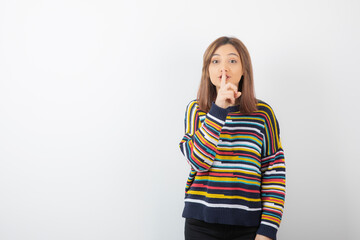 Wall Mural - Photo of a young pretty woman model showing silent sign