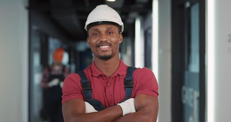 Wall Mural - Portrait of professional young engineer architec afro-american worker in protective uniform smiling posing for camera in construction new building.