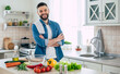 © My Ocean studio - Bearded smiling handsome man in the kitchen at home is posing and looking on the camera