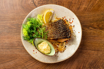 Wall Mural - Piece of fried carp with sauce and lemon on a plate 
