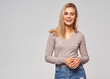 © kiuikson - Lifestyle portrait of cheerful blonde woman isolated on gray background